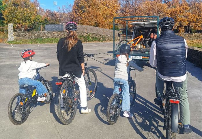 Familia montando en bicicleta por un sendero.