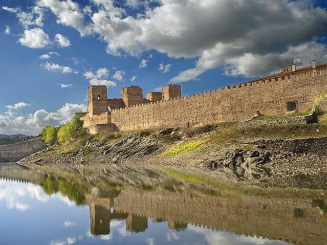 Vista de la oficina de turismo de Buitrago reflejada en el lago.